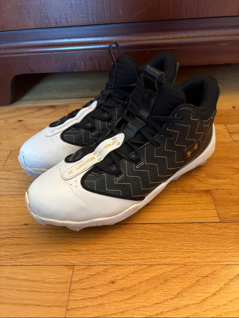 Under Armour Men’s Black and White High-Top Baseball Cleats with Gold Logo